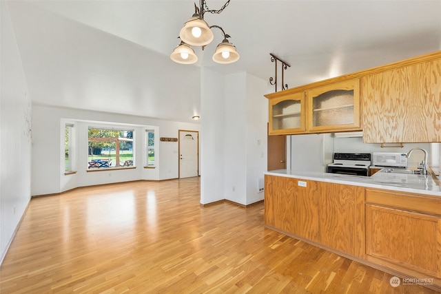 kitchen featuring white electric range, hanging light fixtures, kitchen peninsula, sink, and light wood-type flooring