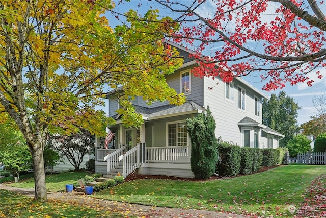 view of front of home with covered porch and a front lawn