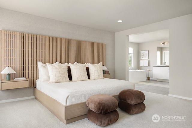 bedroom featuring ensuite bath and light colored carpet