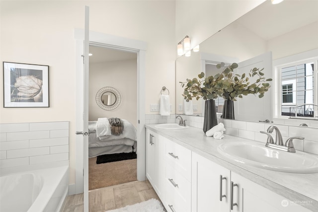 bathroom with vanity, a tub to relax in, and hardwood / wood-style floors