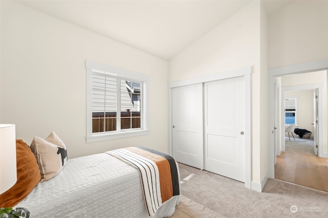 carpeted bedroom with a closet and lofted ceiling