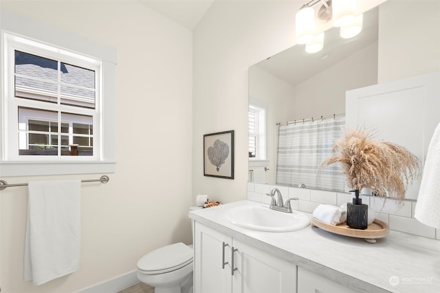 bathroom featuring vanity, lofted ceiling, and toilet