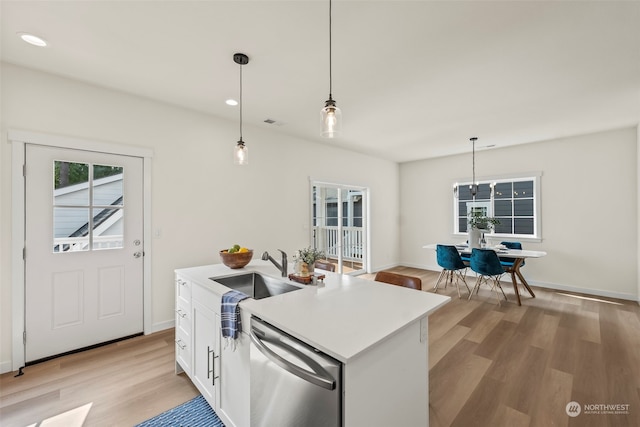 kitchen with dishwasher, white cabinets, sink, and an island with sink