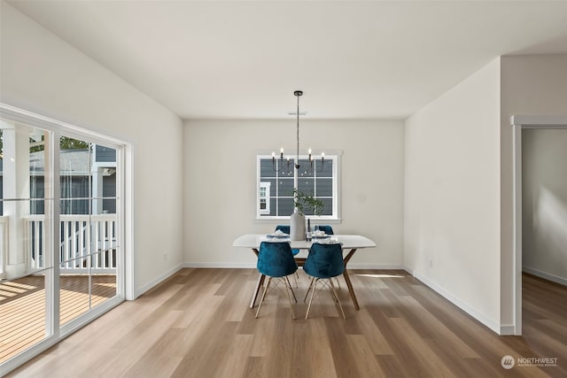 dining space with a notable chandelier and light wood-type flooring