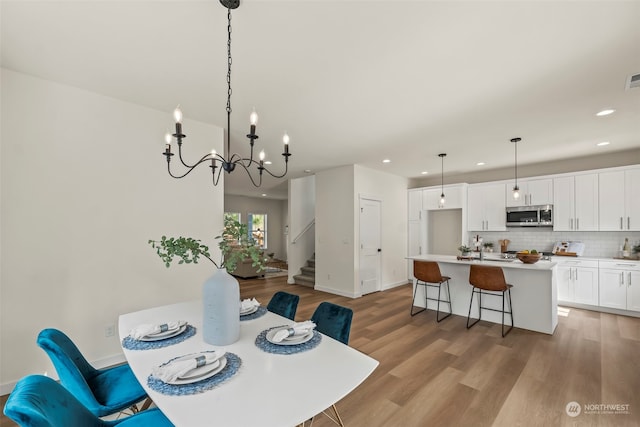 dining space featuring light hardwood / wood-style floors and a notable chandelier