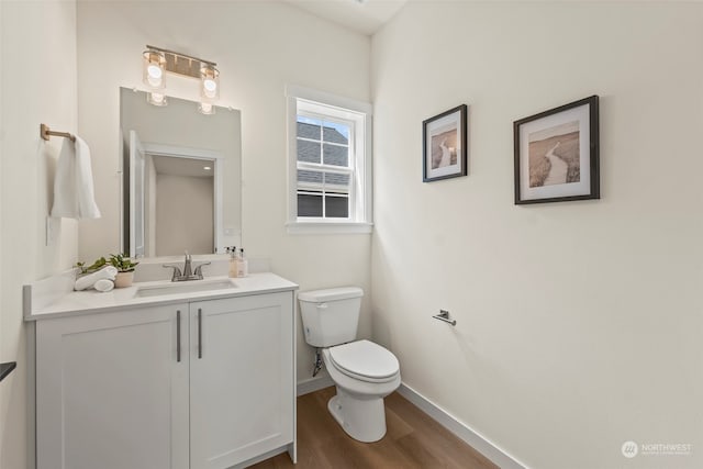 bathroom featuring toilet, hardwood / wood-style floors, and vanity