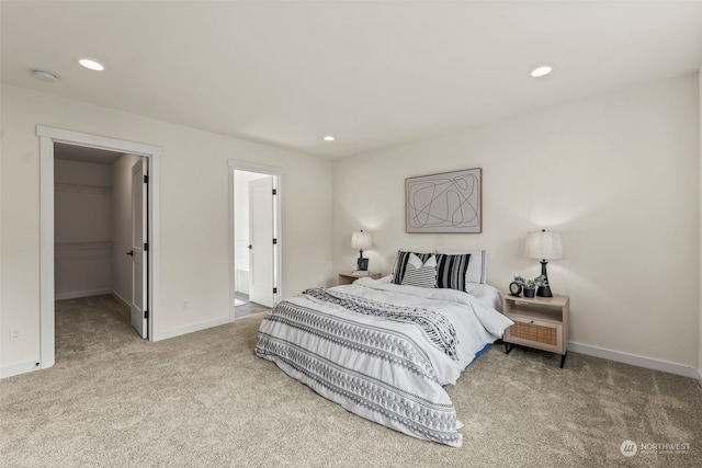 carpeted bedroom featuring a walk in closet