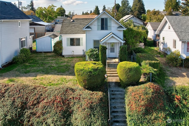 view of front of home featuring a front lawn and a storage unit