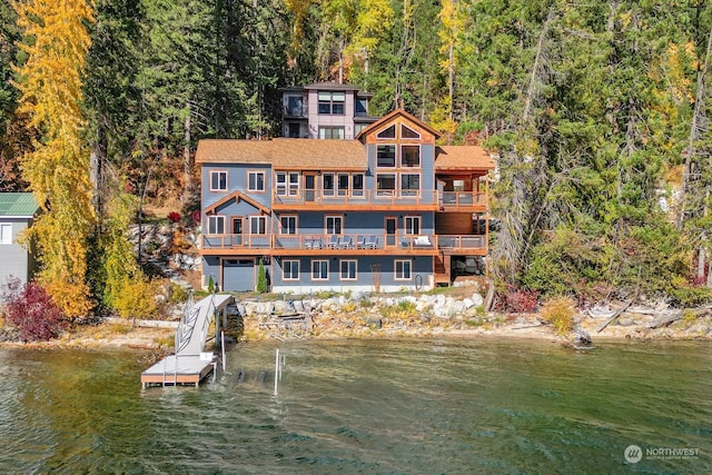 rear view of property featuring a balcony and a water view