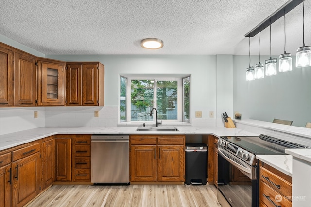 kitchen featuring light hardwood / wood-style floors, kitchen peninsula, stainless steel appliances, and sink