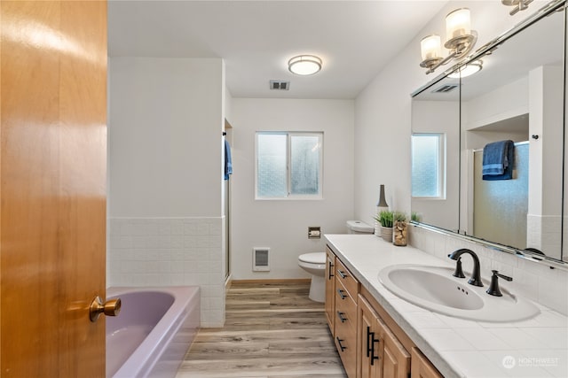 bathroom with vanity, toilet, hardwood / wood-style flooring, and a healthy amount of sunlight