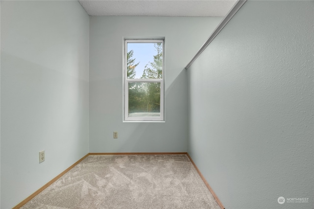 carpeted spare room with a textured ceiling