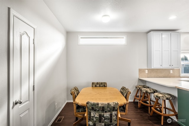 dining space featuring plenty of natural light and dark hardwood / wood-style floors