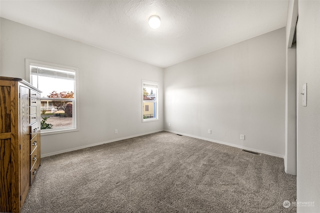 carpeted empty room featuring a textured ceiling