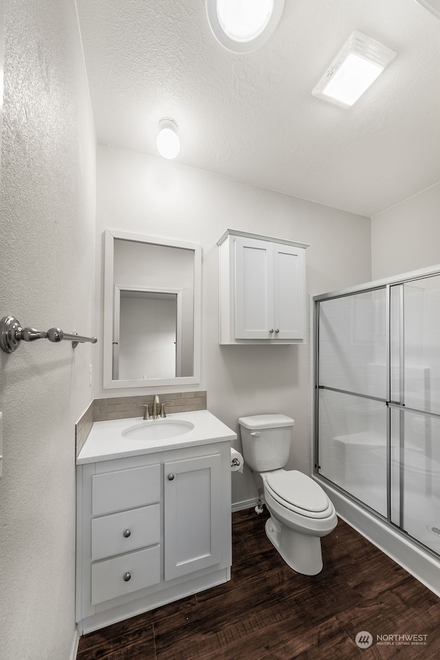 2101 S 324th St Unit 158, Federal Way, WA 98003 - bathroom with toilet, wood finished floors, baseboards, a shower stall, and vanity