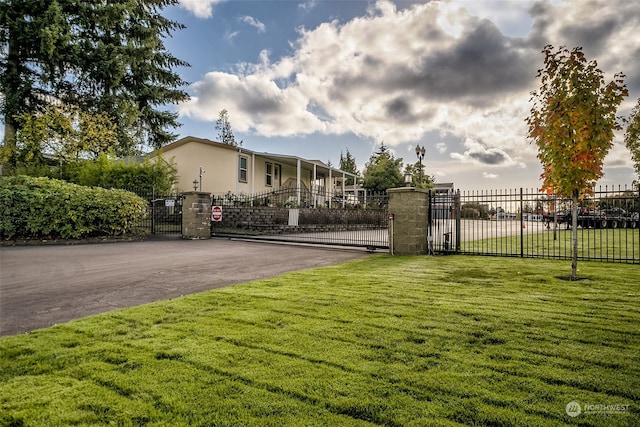 view of gate with a lawn