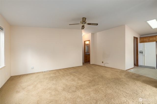 carpeted empty room with a skylight and ceiling fan