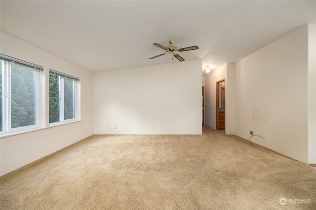 carpeted spare room featuring ceiling fan