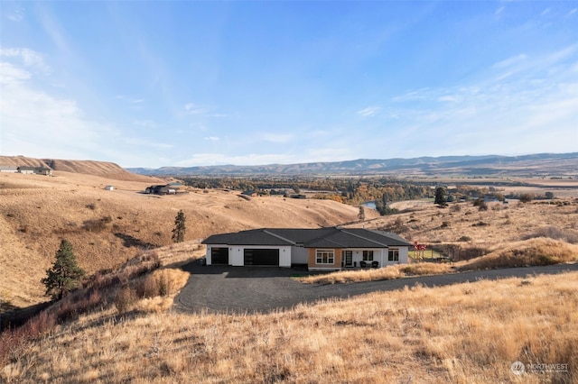 exterior space featuring a mountain view, a garage, and a rural view