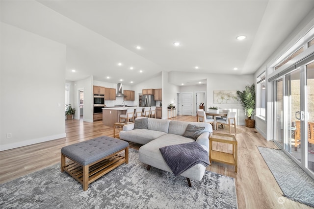 living room with vaulted ceiling and light hardwood / wood-style flooring