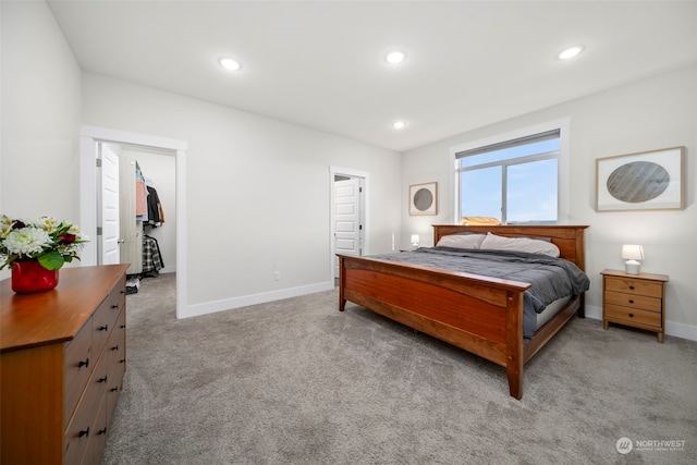 carpeted bedroom with a spacious closet and a closet