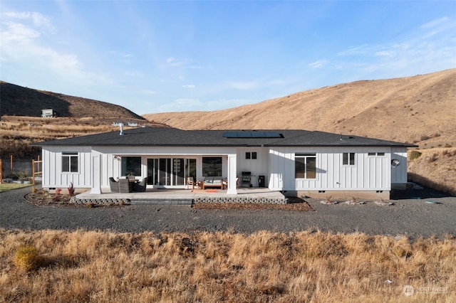 rear view of property featuring a mountain view and a patio