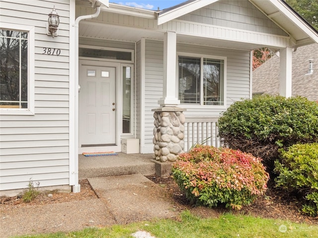 view of exterior entry featuring covered porch