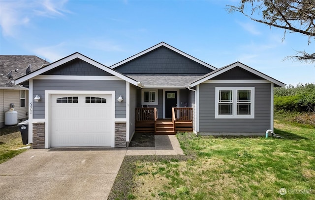 view of front of house featuring stone siding, a front yard, an attached garage, driveway, and a porch