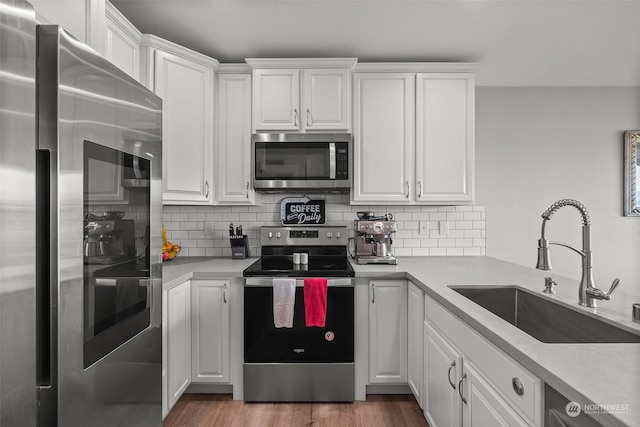 kitchen with a sink, appliances with stainless steel finishes, and white cabinets