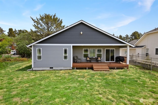 back of property featuring fence, a yard, and a wooden deck