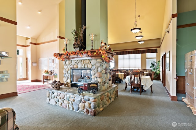 carpeted living room featuring a stone fireplace and high vaulted ceiling