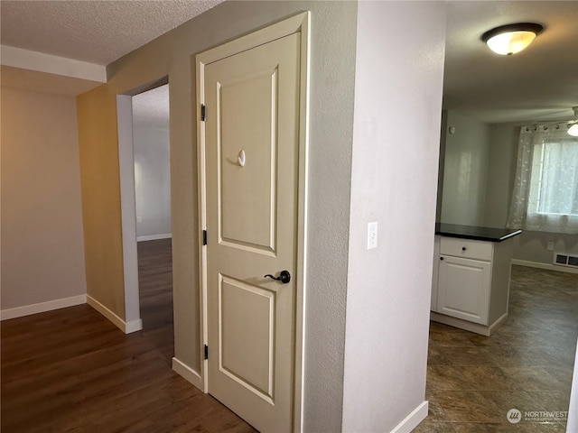 hall featuring dark hardwood / wood-style floors and a textured ceiling