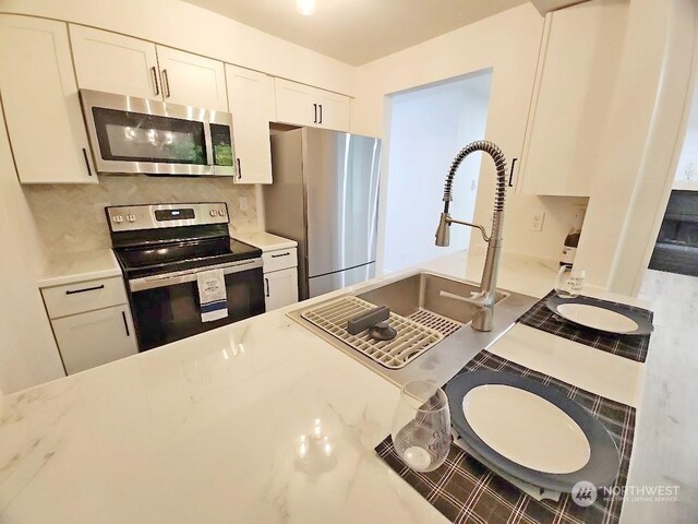 3600 Narrows View Ln Unit 201, Bremerton, WA 98310 - kitchen with stainless steel appliances, tasteful backsplash, white cabinetry, and a sink