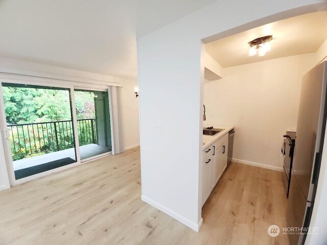 3600 Narrows View Ln Unit 201, Bremerton, WA 98310 - kitchen with light wood-style floors, white cabinetry, baseboards, dishwasher, and light countertops