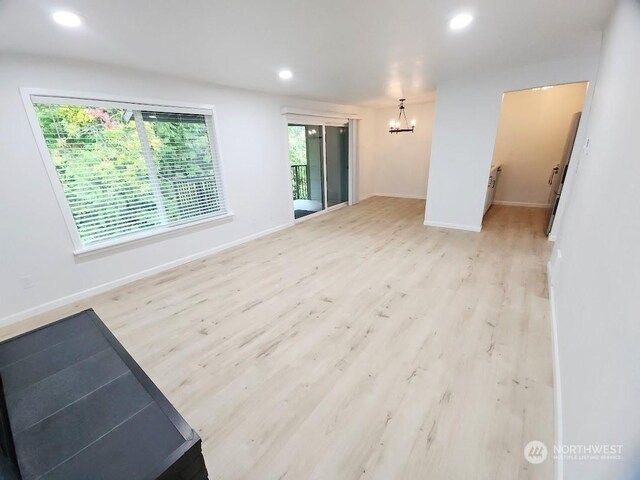 3600 Narrows View Ln Unit 201, Bremerton, WA 98310 - spare room featuring a chandelier, recessed lighting, wood finished floors, and baseboards