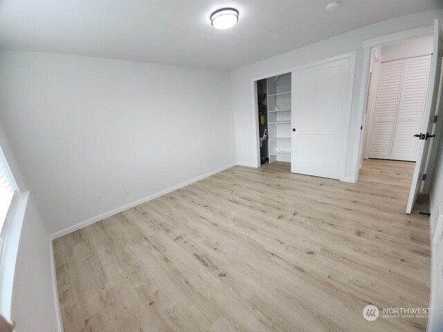 3600 Narrows View Ln Unit 201, Bremerton, WA 98310 - unfurnished bedroom with light wood-style flooring, a closet, and baseboards