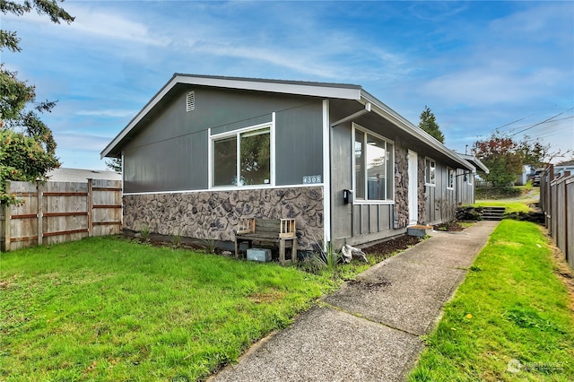 view of side of home with a yard