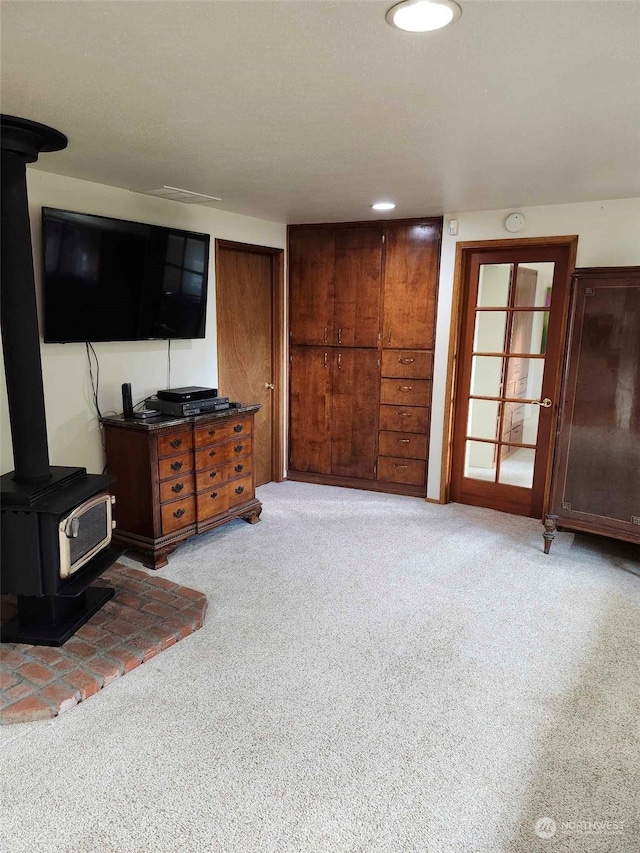 carpeted living room featuring a wood stove