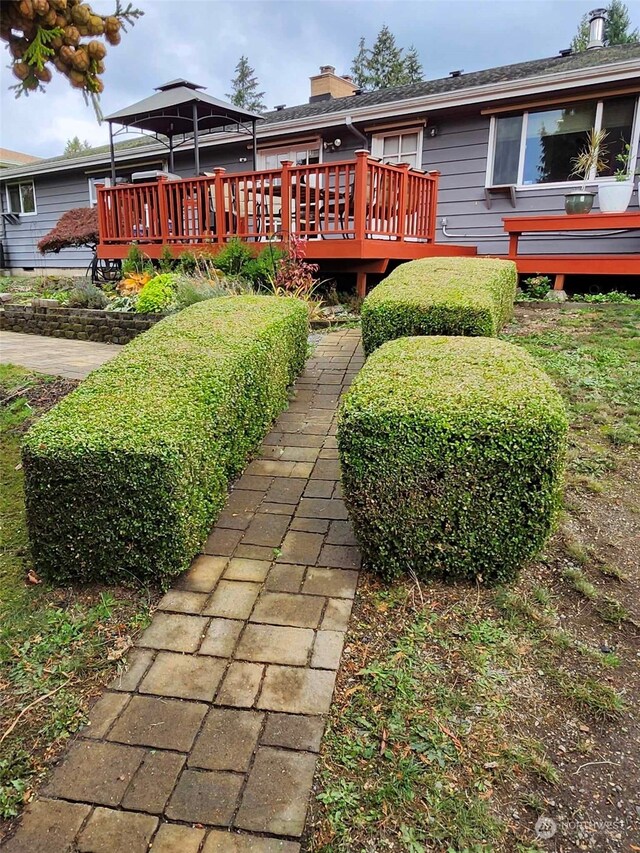 rear view of house featuring a wooden deck