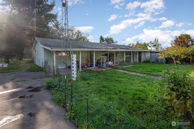 rear view of house featuring a yard and a porch