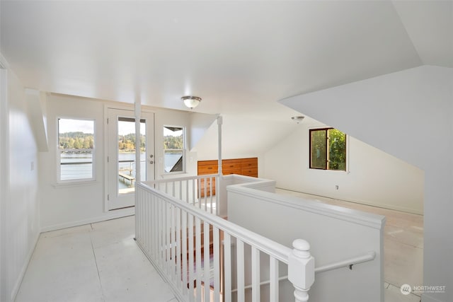 hall with a healthy amount of sunlight and lofted ceiling