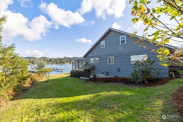 view of side of home with a yard and a water view