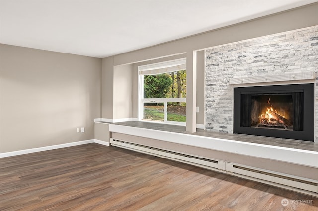 interior space featuring a stone fireplace, hardwood / wood-style floors, and a baseboard radiator