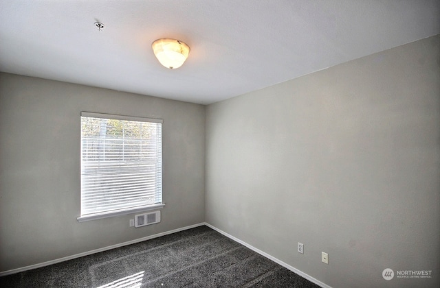 empty room with dark colored carpet