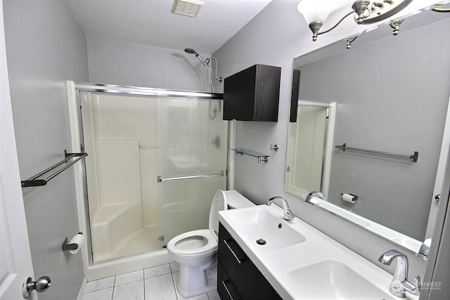 bathroom with toilet, a shower with shower door, vanity, and tile patterned flooring