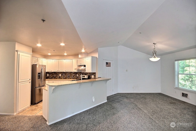 kitchen featuring light colored carpet, kitchen peninsula, stainless steel appliances, and a breakfast bar area