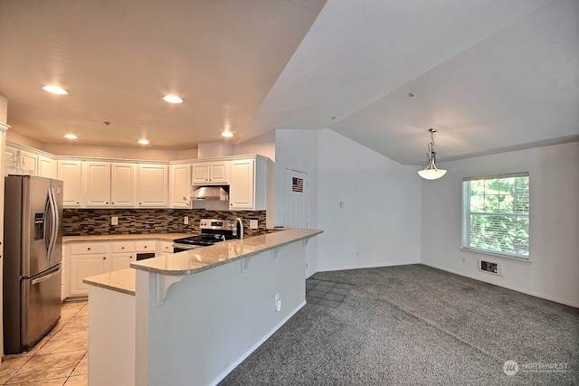 kitchen featuring a breakfast bar, appliances with stainless steel finishes, light carpet, and white cabinets