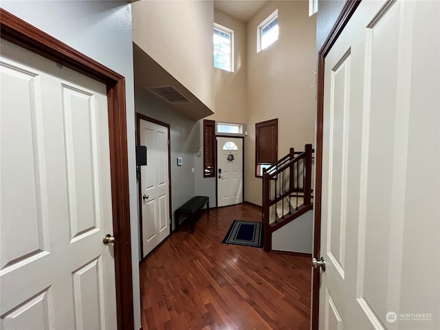 interior space featuring dark wood-type flooring and a high ceiling