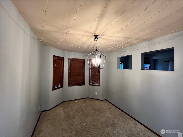 unfurnished dining area with a chandelier and carpet flooring