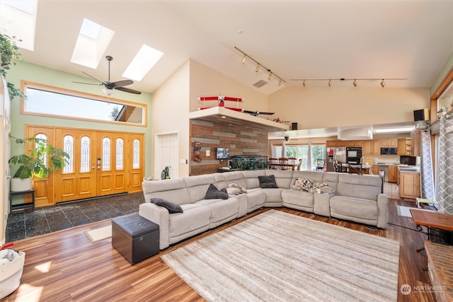 living room featuring a wealth of natural light, track lighting, dark hardwood / wood-style floors, and high vaulted ceiling